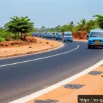 감비아 도로 상태 - A detailed scene of the Transgambia Highway during daylight, showing a paved road with visible patch...